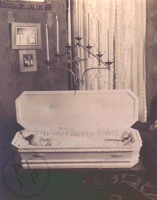 Child in a casket with candle stand