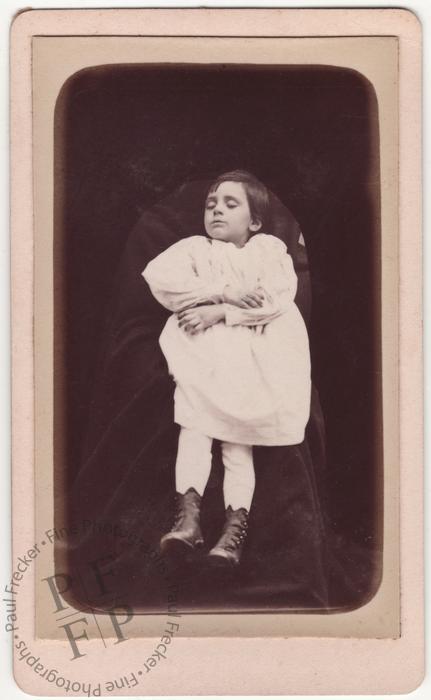 Small child in a white shirt and leather boots