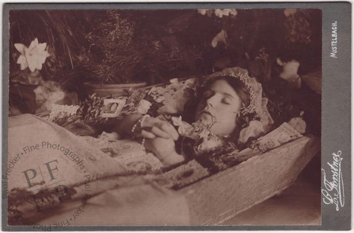 Woman in a coffin with prayer cards