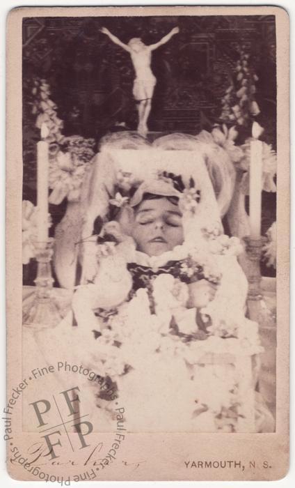 Child with a crucifix and candles