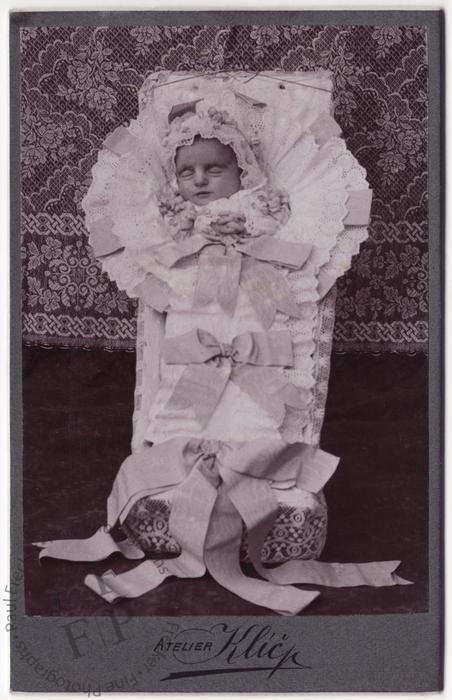 Baby in a coffin with ribbons