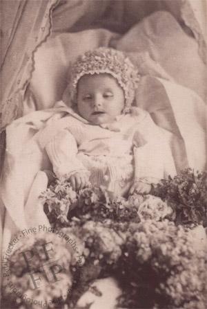 Baby in a cot with flowers