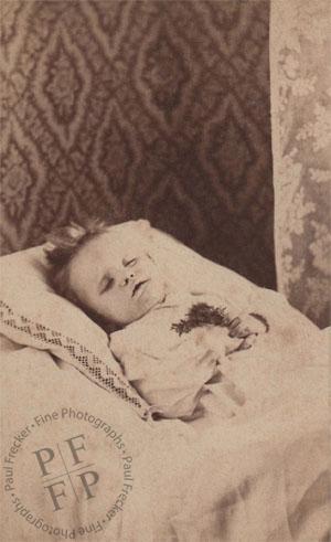 Infant with sprig of flowers