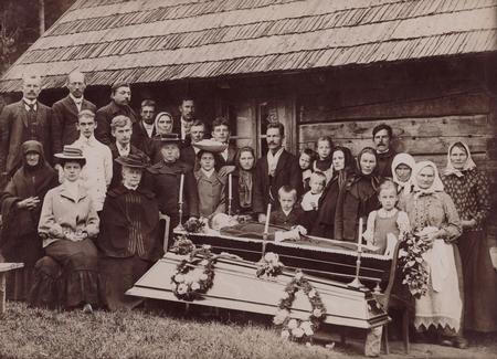 Mourners beside an open coffin